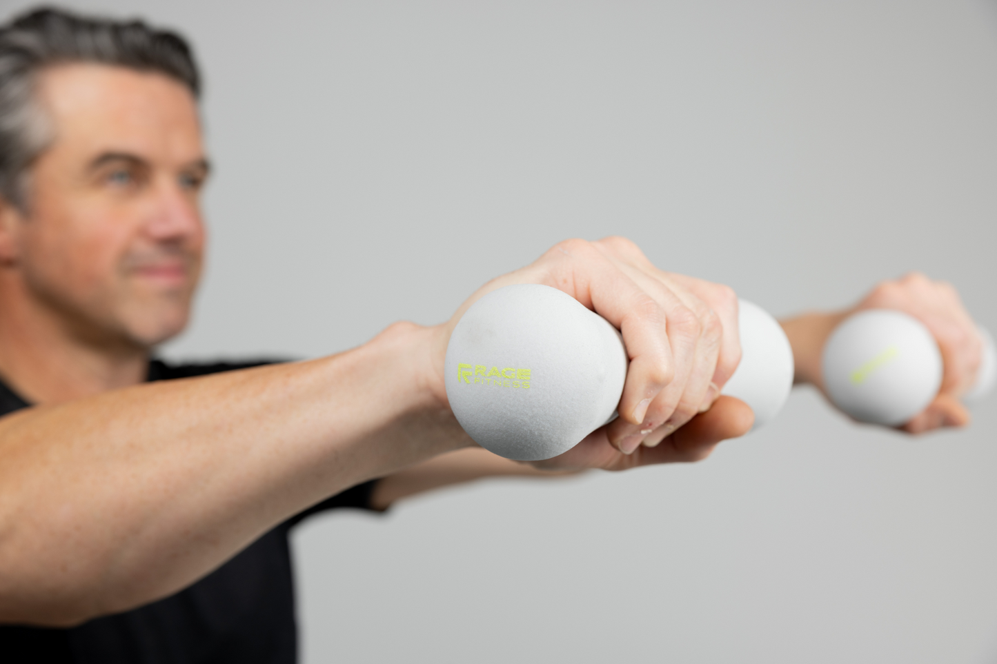 Man lifting pair of 5 lb hand weights by Rage Fitness