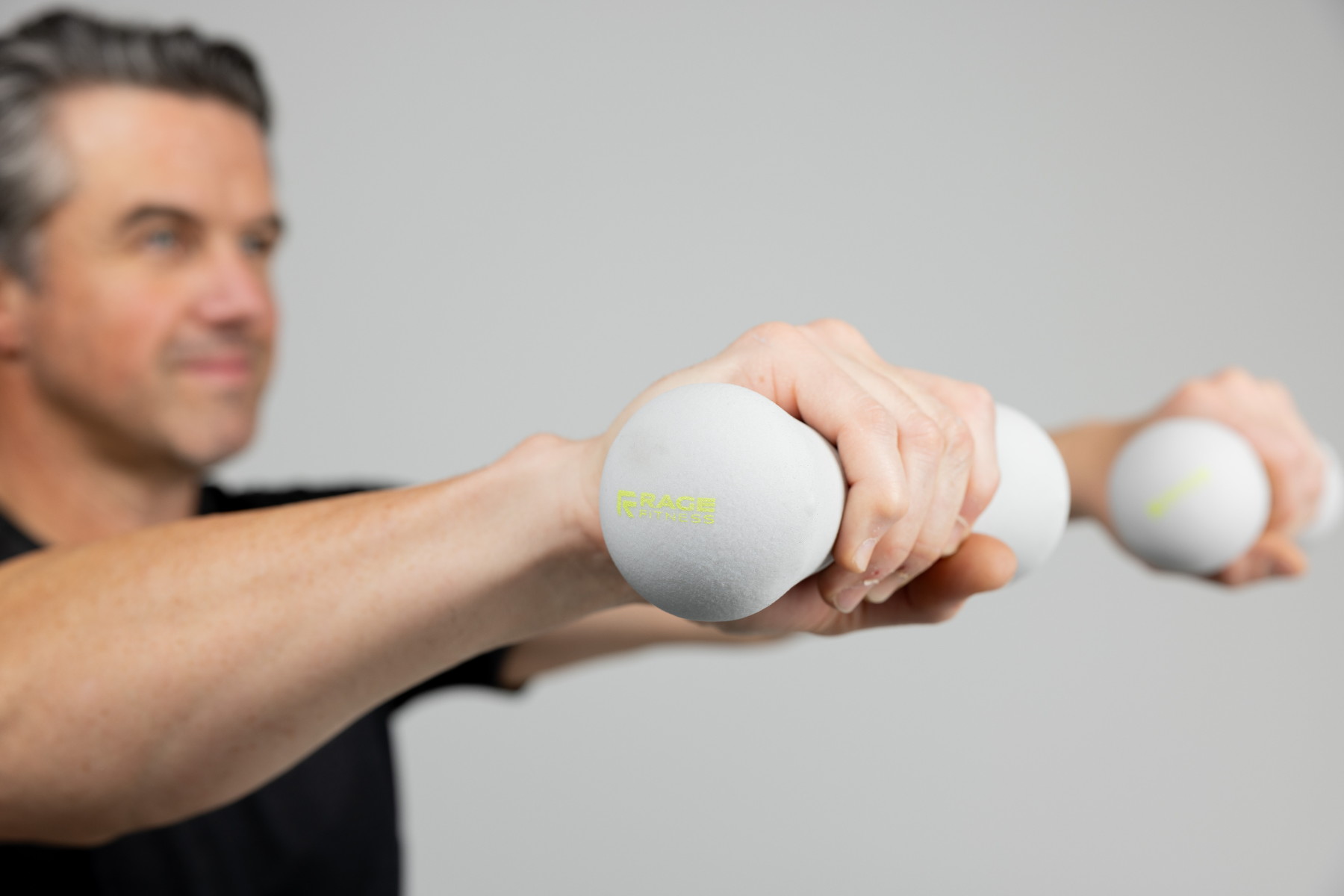 Man lifting pair of 5 lb hand weights by Rage Fitness