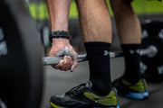 Man lifting barbell with chalk on his hands