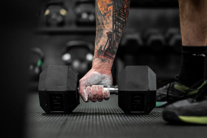 Man picking up dumbbell with RAGE Fitness Chalk Powder on his hands