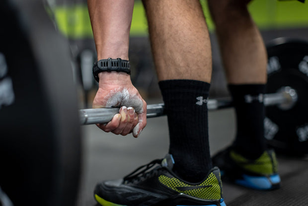 Man lifting barbell with RAGE Fitness Chalk Powder on his hands