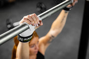 Woman holding onto bar with RAGE Fitness Lift Grips on her hands